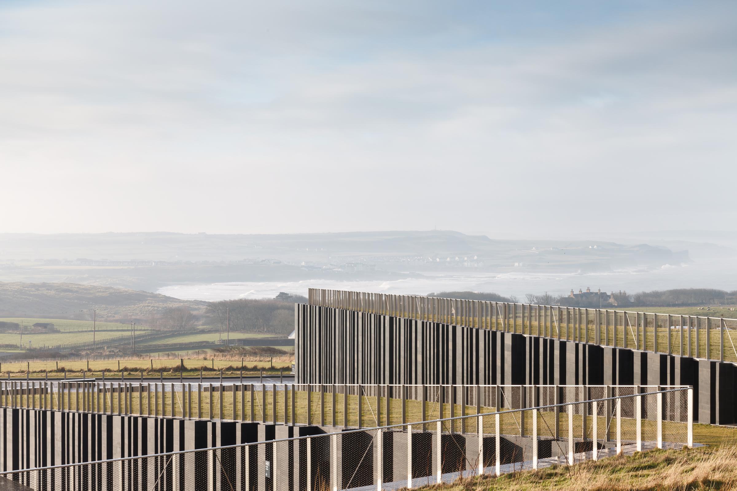 Photograph of Giants Causway Visitor Centre, designed by Heneghan Peng Architects and located in Bushmills, United Kingdom